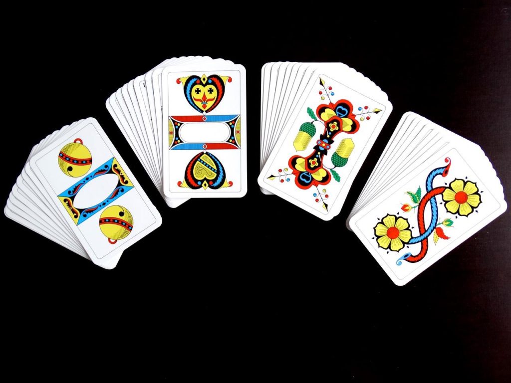 Familie speelt kwartet samen aan tafel als gezinsentertainment zonder schermen